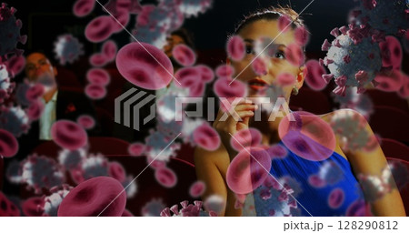 Woman in theater watching movie, surrounded by digital virus and blood cells Woman in theater watching movie, surrounded by digital virus and blood cells 128290812