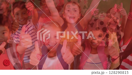 Digital composite image of covid-19 cells moving against group of kids showing thumbs up at school Digital composite image of covid-19 cells moving against group of kids showing thumbs up at school 128290815