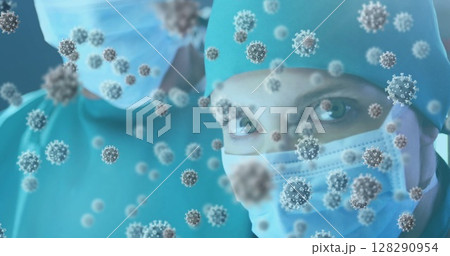 Image of 3d covid 19 cells floating over female doctor in face mask 128290954