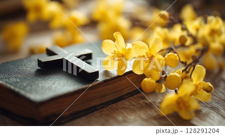 Beautiful yellow flowers surround a cross and holy bible in a serene worship setting 128291204