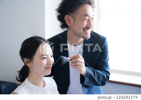 メイクブラシを持つヘアメイクの男性と女性　メイクアップのイメージ 128291274