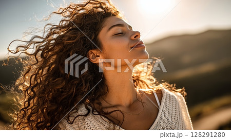 Young woman enjoys warm sunlight while practicing mindfulness and cultivating well-being in a serene outdoor setting 128291280