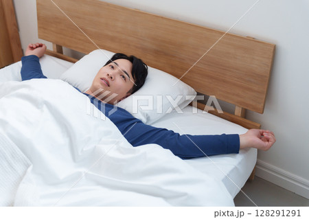 ベッドで休む憂鬱な男性 ベッドで休む憂鬱な男性 128291291