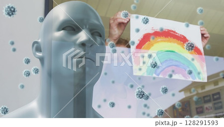 Image of covid 19 cells over model head with person in face mask holding rainbow drawing Image of covid 19 cells over model head with person in face mask holding rainbow drawing 128291593