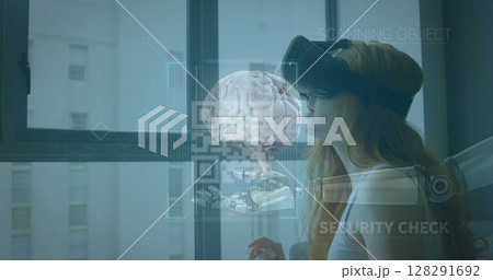 Image of human brain, scope over robot's arm and woman wearing vr headset in background Image of human brain, scope over robot's arm and woman wearing vr headset in background 128291692