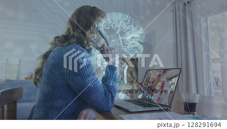 Image of digital human head, network of connections over woman using laptop on image call Image of digital human head, network of connections over woman using laptop on image call 128291694
