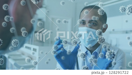 Image of covid 19 cells and male doctor wearing mask showing vaccine to man 128291722