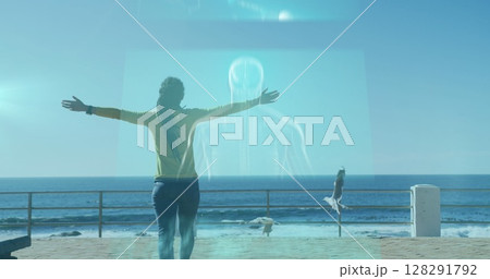 Image of screens floating over woman walking on promenade by the sea Image of screens floating over woman walking on promenade by the sea 128291792