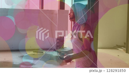 Colorful spots of lights moving against african american woman jumping ropes 128291850