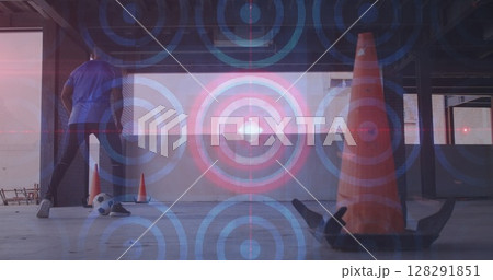 Multiple circular shapes and spot of light moving against african american man practicing soccer 128291851