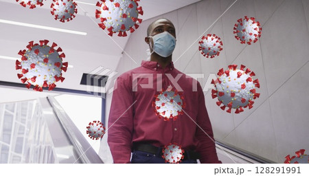 Covid-19 cells floating against african american senior man wearing face mask using escalator 128291991