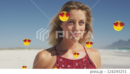 Image of red heart love emojis digital icons over smiling woman on beach 128293251