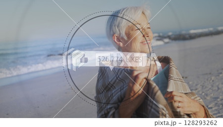 Image of speech bubble with thumbs up icon and numbers over senior woman on beach Image of speech bubble with thumbs up icon and numbers over senior woman on beach 128293262