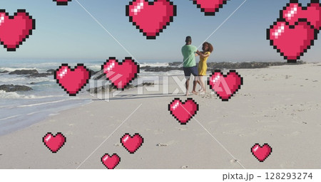 Image of heart digital icons over couple dancing on beach 128293274