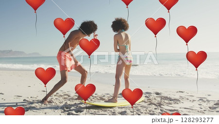 Image of heart icons over couple with surfboard on beach 128293277