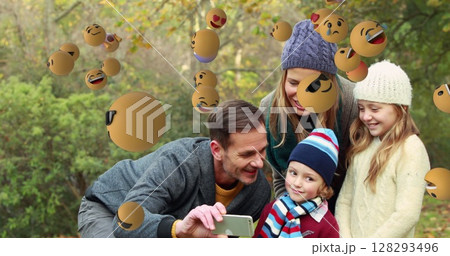 Family taking selfie outdoors surrounded by floating emojis, enjoying playful moment Family taking selfie outdoors surrounded by floating emojis, enjoying playful moment 128293496