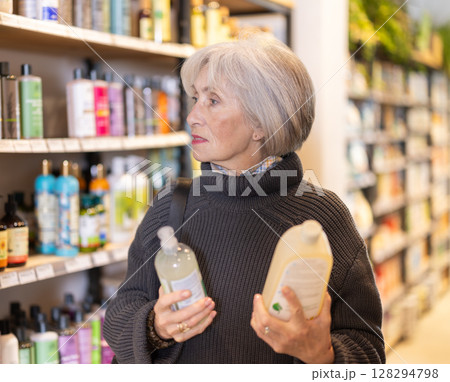 Senior woman reads label, choose and compare shampoo Senior woman reads label, choose and compare shampoo 128294798