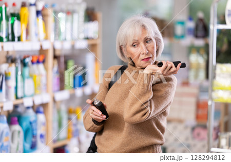 Mature woman choosing perfume in department store 128294812