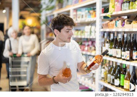 Guy choosing wine in the store 128294913