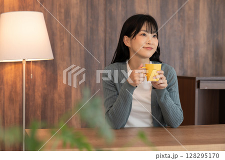 部屋でリラックスする若い女性 128295170