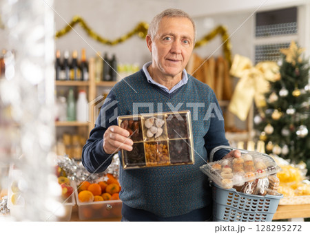 Elderly man selects dried fruits and panellets at grocery 128295272