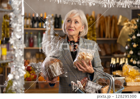 Elderly woman chooses between marzipan and panettone Elderly woman chooses between marzipan and panettone 128295300