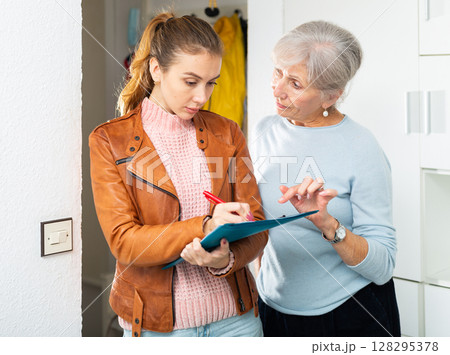 Senior and younger women filling rent contract Senior and younger women filling rent contract 128295378