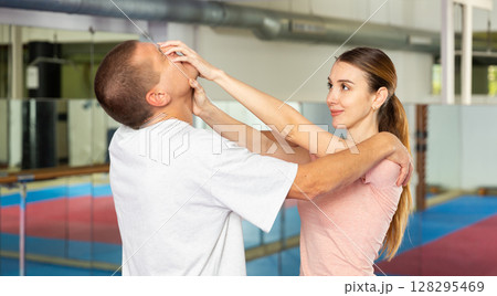 Self-defense course - woman strikes painful blow in the eyes of man Self-defense course - woman strikes painful blow in the eyes of man 128295469