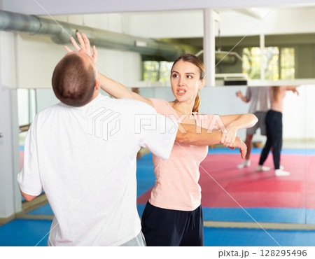 Woman and man practicing self defense techniques 128295496