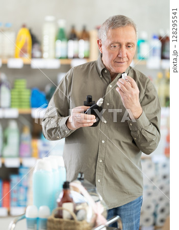 Elderly man choosing perfume in a European supermarket Elderly man choosing perfume in a European supermarket 128295541
