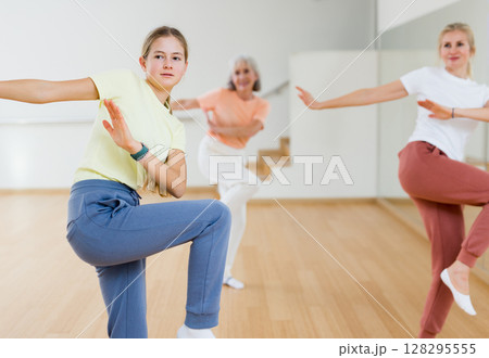 Happy teen girl with family training movements of dance in choreography class 128295555