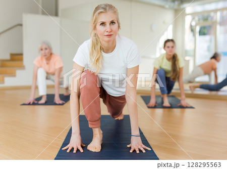 Woman practicing yoga in studio Woman practicing yoga in studio 128295563