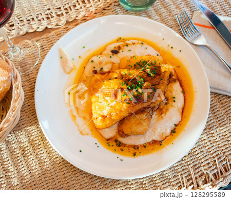 Few pieces of fried cod fillet and side dish of potatoes. 128295589