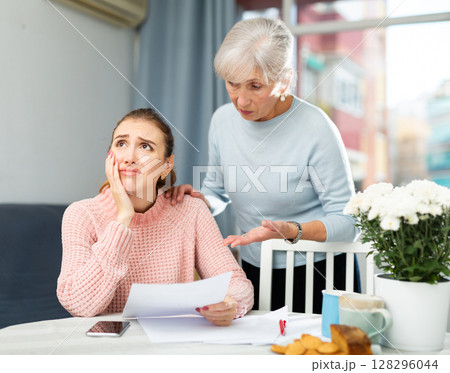Young woman with financial problems and her mother at home Young woman with financial problems and her mother at home 128296044