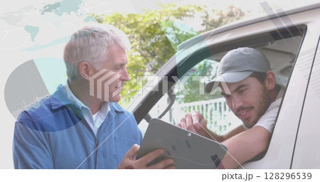 Statistical data processing against senior male worker and delivery man discussing over clipboard 128296539