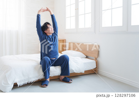 朝ベッドから起きてストレッチする男性 128297106