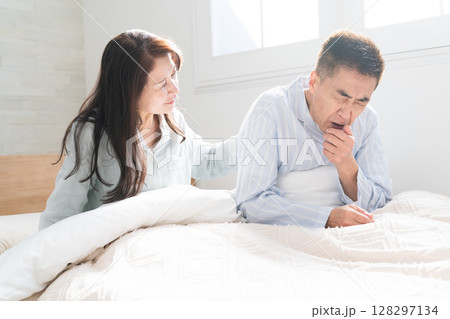 起きてベッドの上で会話をする夫婦 起きてベッドの上で会話をする夫婦 128297134