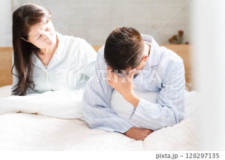 起きてベッドの上で会話をする夫婦 起きてベッドの上で会話をする夫婦 128297135