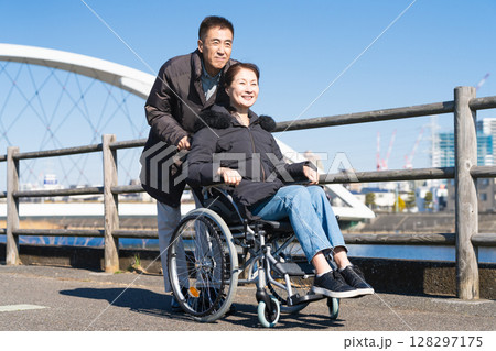 車椅子を押して散策をする親子 128297175