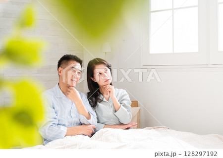 起きてベッドの上で会話をする夫婦 128297192