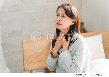 起きてベッドの上でのどの痛みを訴える女性 起きてベッドの上でのどの痛みを訴える女性 128297202