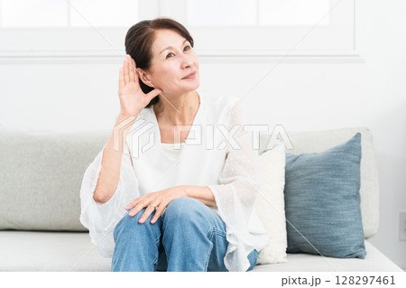耳に手を当てて聞きかえす熟年女性 128297461
