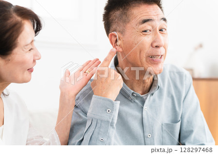 補聴器を付けた熟年男性と喜ぶ女性 補聴器を付けた熟年男性と喜ぶ女性 128297468