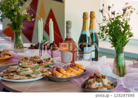 Elegant Champagne Brunch Spread on Pink Tablecloth with Flowers and Candles, Vibrant Interior Background, Festive Party Still Life. 128297898