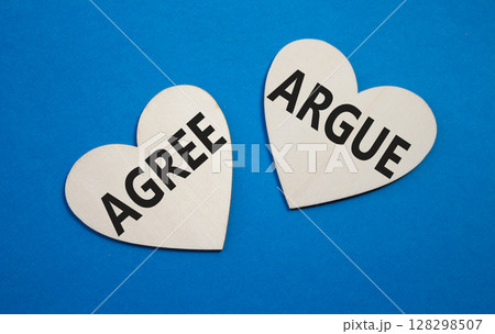 Agree or Argue symbol. Concept word Agree or Argue on wooden hearts. Beautiful blue background. Business and Agree or Argue concept. Copy space Agree or Argue symbol. Concept word Agree or Argue on wooden hearts. Beautiful blue background. Business and Agree or Argue concept. Copy space 128298507