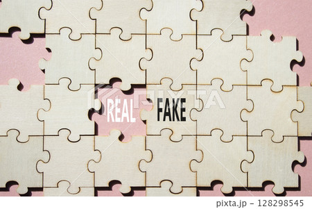 Real or Fake symbol. Concept word Real or Fake on wooden blocks. Beautiful pink background. Business and Real or Fake concept. Copy space 128298545