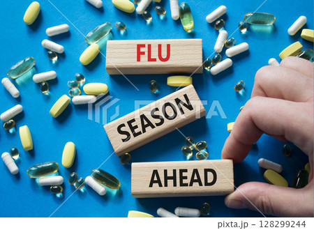Flu Season Ahead symbol. Concept word Flu Season Ahead on wooden blocks. Doctor hand. Beautiful blue background with pills. Medicine and Flu Season Ahead concept. Copy space Flu Season Ahead symbol. Concept word Flu Season Ahead on wooden blocks. Doctor hand. Beautiful blue background with pills. Medicine and Flu Season Ahead concept. Copy space 128299244