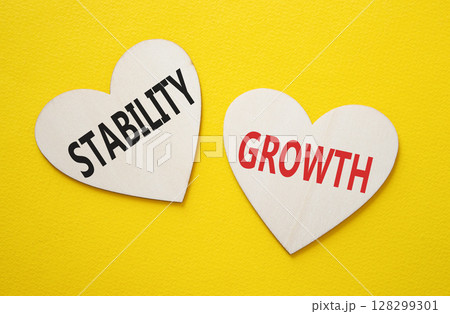 Growth and Stability symbol. Concept word Growth and Stability on wooden hearts. Beautiful yellow background. Business and Growth and Stability concept. Copy space Growth and Stability symbol. Concept word Growth and Stability on wooden hearts. Beautiful yellow background. Business and Growth and Stability concept. Copy space 128299301