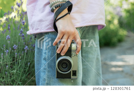 Photographer holding vintage camera in lavender field Photographer holding vintage camera in lavender field 128301761