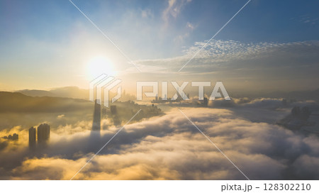 March 2 2025 Captivating Urban Skyline Shrouded in Morning Mist During Sunset 128302210